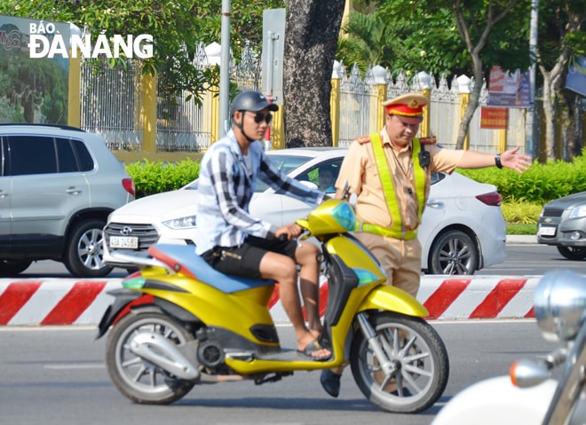 Đội Tuần tra -Dẫn đoàn triển khai nhiệm vụ tại phía tây cầu Rồng. Hơn 30 phút, nhiều phương tiện bị dừng kiểm tra hành chính về lĩnh vực giao thông đường bộ. Ảnh NGỌC PHÚ