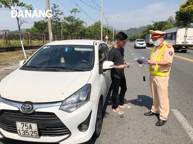 Trong buổi sáng đầu tiên, Trạm Cảnh sát giao thông cửa ô Hòa Hiệp đã phát hiện 2 trường hợp xe ô tô con chở khách đông đúng quy định, không có hợp đồng chở khách, không có phù hiệu. Ảnh NGỌC PHÚ