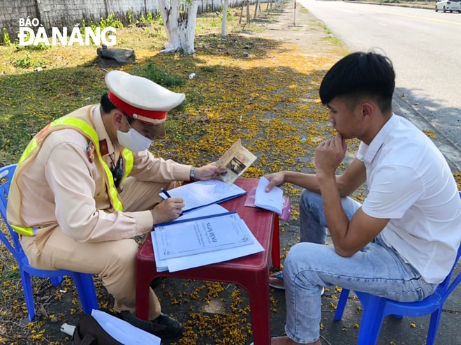 Cảnh sát giao thông tiến hành lập biên bản để xử lý các hành vi vi phạm trật tự an toàn giao thông theo quy định. Ảnh NGỌC PHÚ