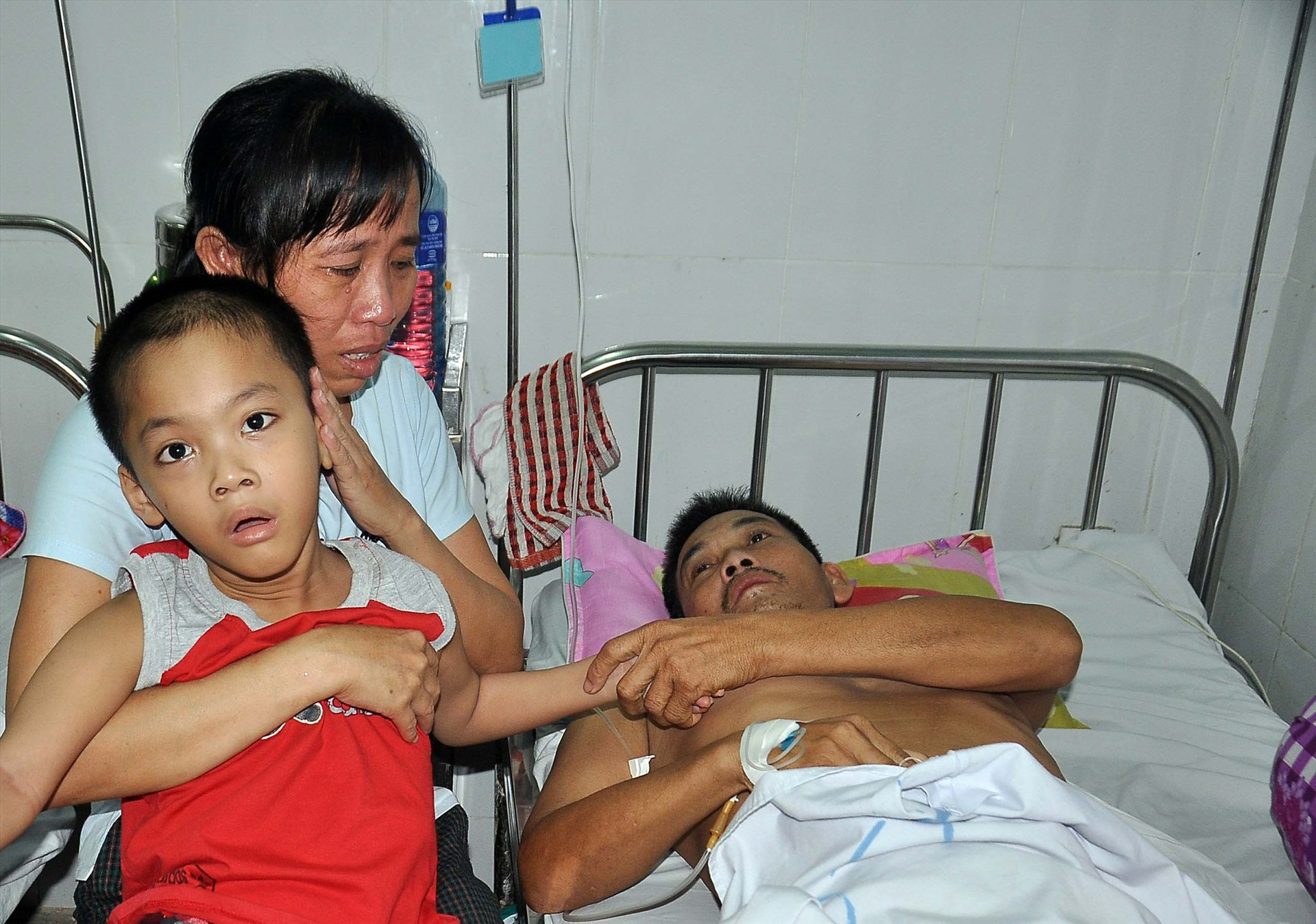 Chị Bùi Thị Lý và đứa con trai mắc bệnh bại não đến thăm chồng tại Bệnh viện Đa khoa Quảng Nam. Ảnh: V.A