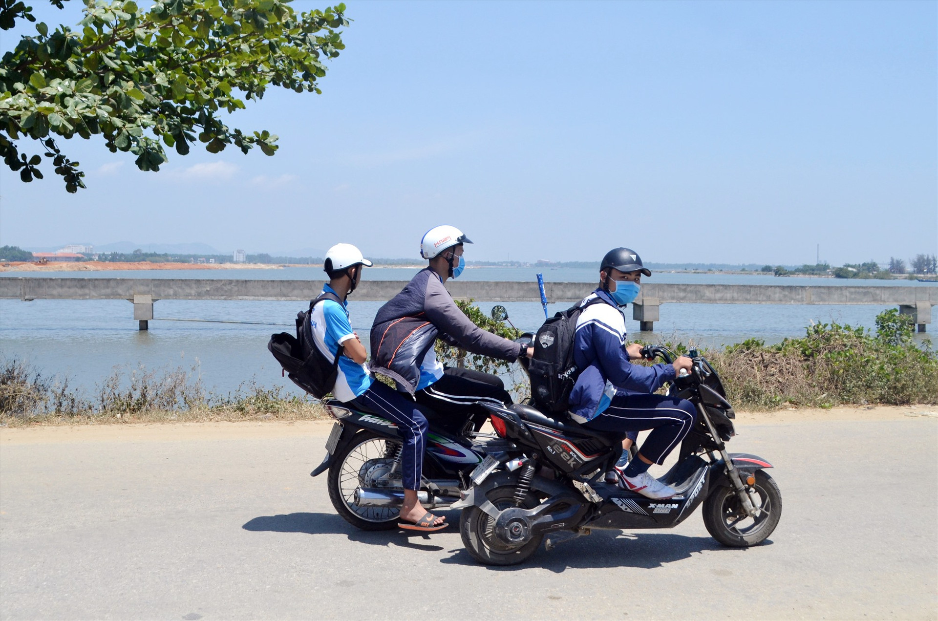Học sinh đi xe máy dùng chân đẩy xe đạp điện trên một tuyến đường nội thị thị trấn Núi Thành (Núi Thành). Ảnh: K.K