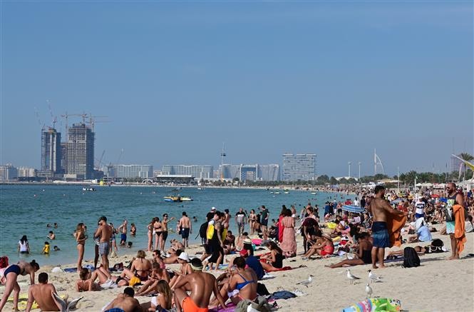  Người dân tắm nắng trên bãi biển ở Dubai, UAE, ngày 13-3-2020. Ảnh: AFP-TTXVN
