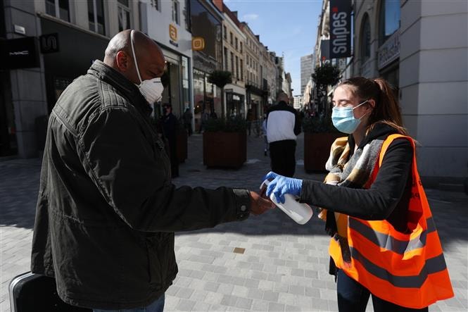 Xịt nước sát khuẩn tay cho người dân tại Brussels, Bỉ ngày 11/5/2020. Ảnh: THX/ TTXVN
