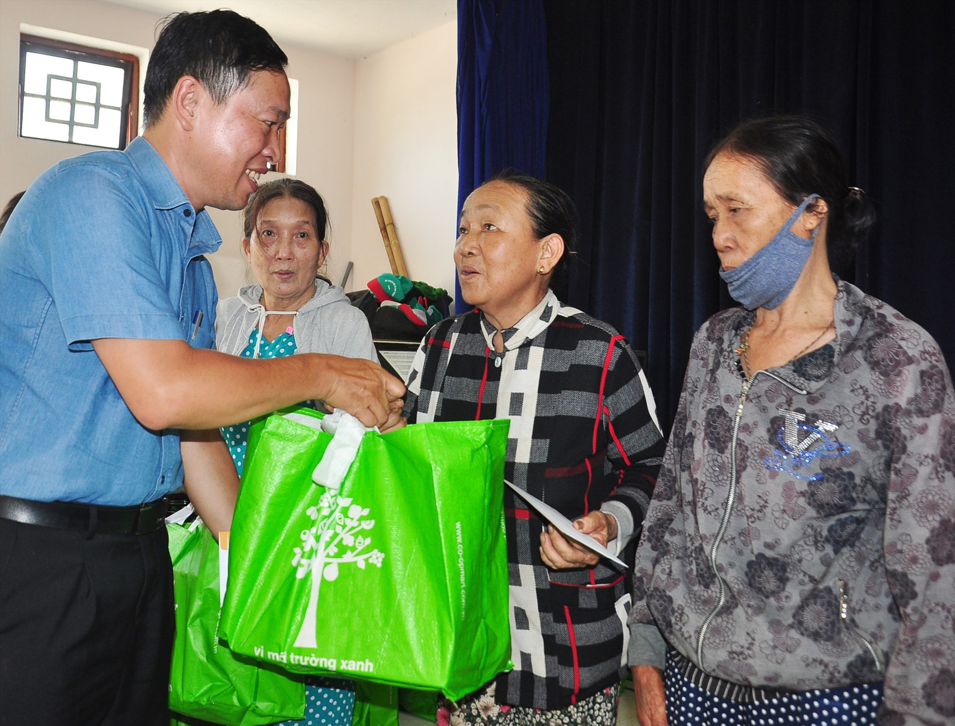 Ông Lê Định - Trưởng văn phòng Trung Trung Bộ Tập đoàn T&T tặng quà người dân xã Tam Thăng. Ảnh: VINH ANH