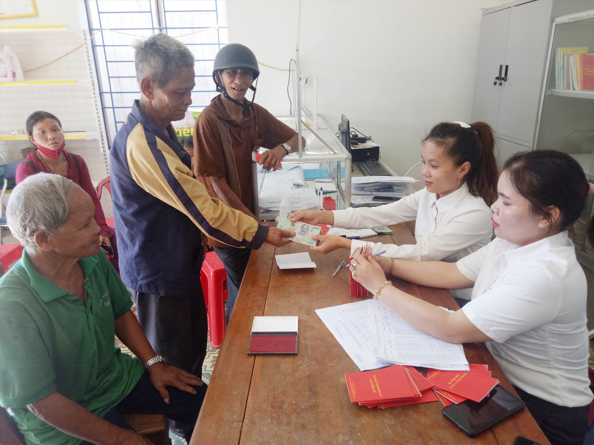 Nhân viên bưu điện chi trả tiền hỗ trợ cho người dân tại xã A Tiêng, huyện Tây Giang. Ảnh: Đ.H