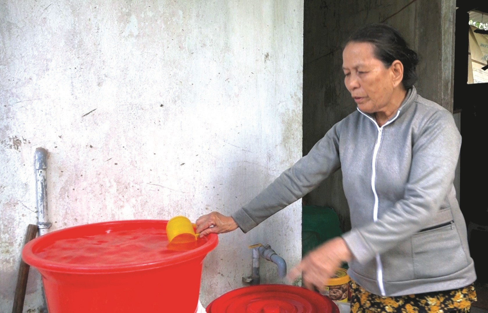 Bà Nguyễn Thị Bốn dùng nhiều thùng lớn để chứa mới đủ nước sinh hoạt. Ảnh: T.B