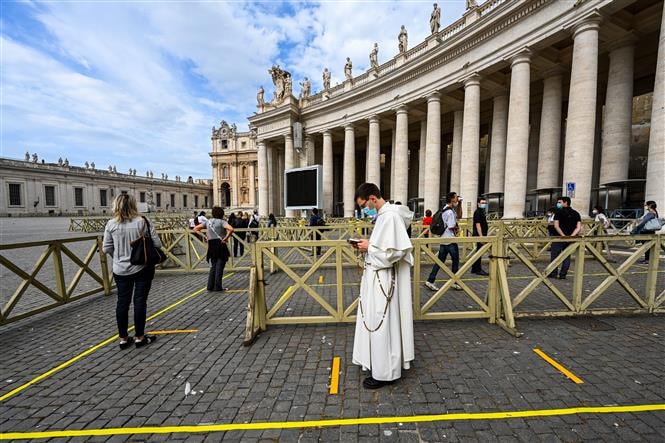  Du khách xếp hàng chờ kiểm tra thân nhiệt trước khi vào Nhà thờ Thánh Peter tại Tòa thánh Vatican ngày 18-5-2020. Ảnh: AFP-TTXVN