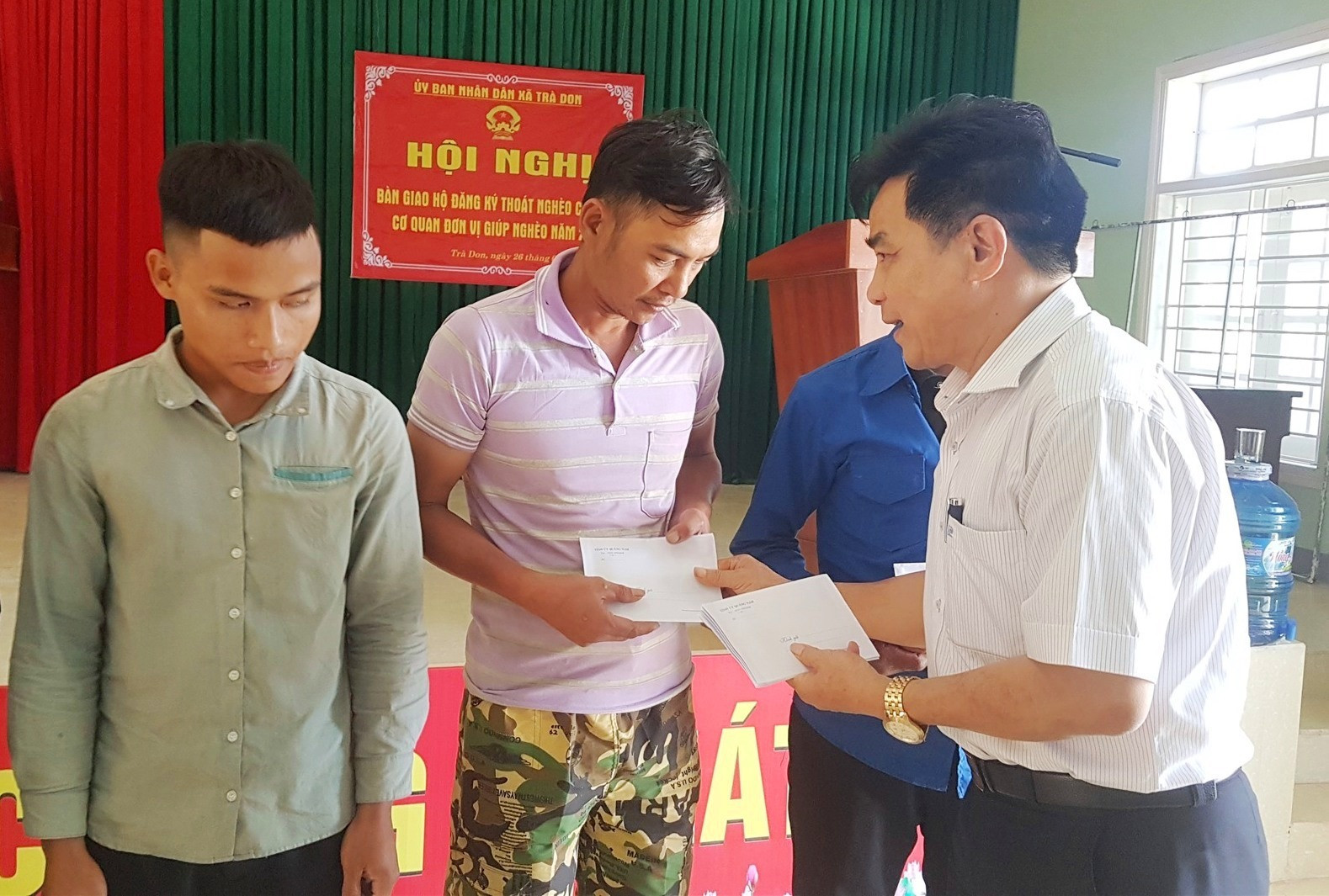 Đồng chí Lê Văn Dũng tặng quà động viên các gia đình tại xã Trà Don. Ảnh: D.L