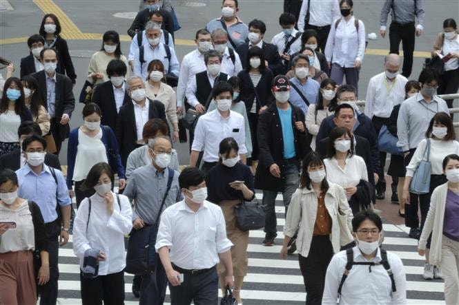 Người dân đeo khẩu trang phòng dịch COVID-19 khi di chuyển trên phố ở Tokyo, Nhật Bản ngày 26/5/2020. Ảnh: AFP/TTXVN