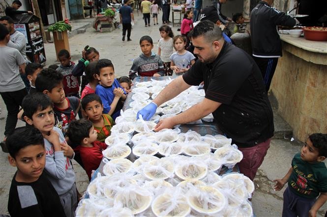 Người Palestine phân phát thức ăn miễn phí nhân tháng lễ Ramadan ở Deir al-Balah, miền Trung Dải Gaza ngày 27/4/2020. Ảnh: THX/TTXVN