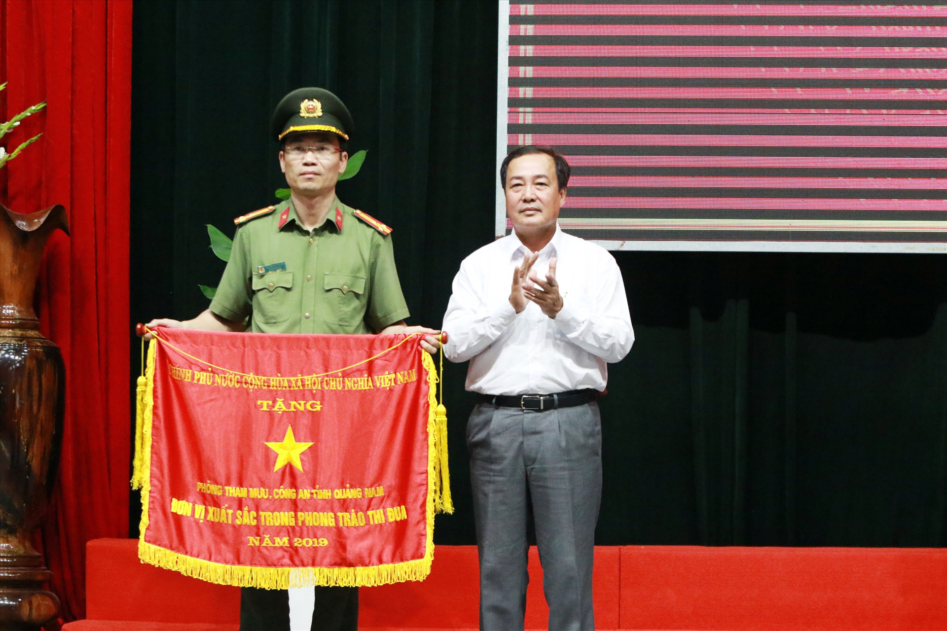 Phó Chủ tịch Thường trực UBND tỉnh Huỳnh Khánh Toàn thừa ủy nhiệm trao Cờ đơn vị xuất sắc trong phong trào thi đua năm 2019 của Chính phủ cho đại diện Phòng Tham mưu Công an tỉnh. Ảnh: T.C