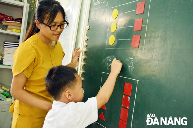 Trở lại trường sau thời gian dài nghỉ học vì Covid-19, những em chưa tiếp cận được các chương trình dạy học online, giáo viên tiến hành kèm cặp, phụ đạo. TRONG ẢNH: Giáo viên Trường tiểu học xã Hòa Bắc hướng dẫn học sinh làm bài tập.                             Ảnh: NGỌC PHÚ