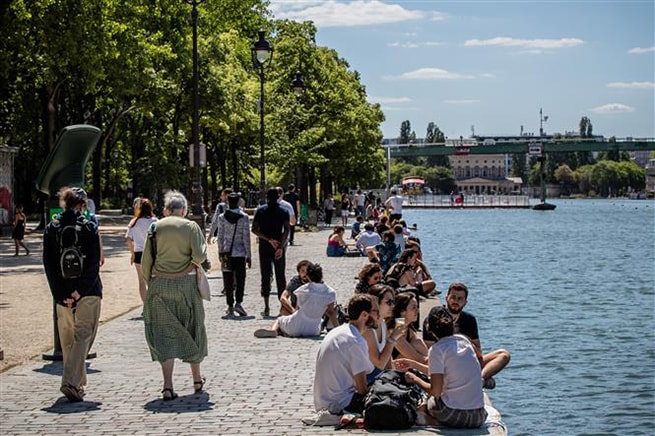 Người dân sưởi nắng thư giãn bên bờ sông ở Paris, Pháp ngày 31-5-2020. Ảnh: THX/TTXVN