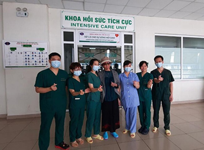 Bệnh nhân số 19 (đứng giữa) chụp ảnh kỷ niệm cùng các y bác sĩ khoa Hồi sức tích cực trước khi trở về.