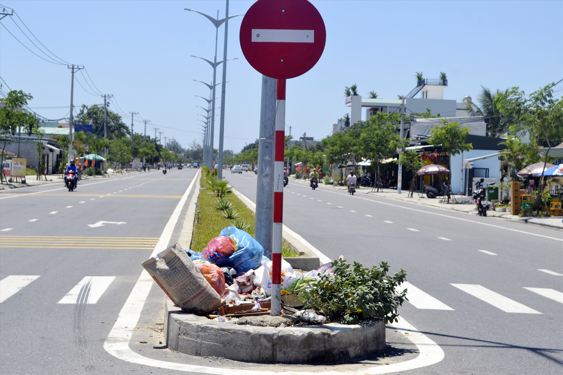 Dải phân cách đường ĐT607 bị một số người dân phường Điện Nam Đông (Điện Bàn) “tận dụng” làm bồn chứa rác thải. Ảnh: K.K