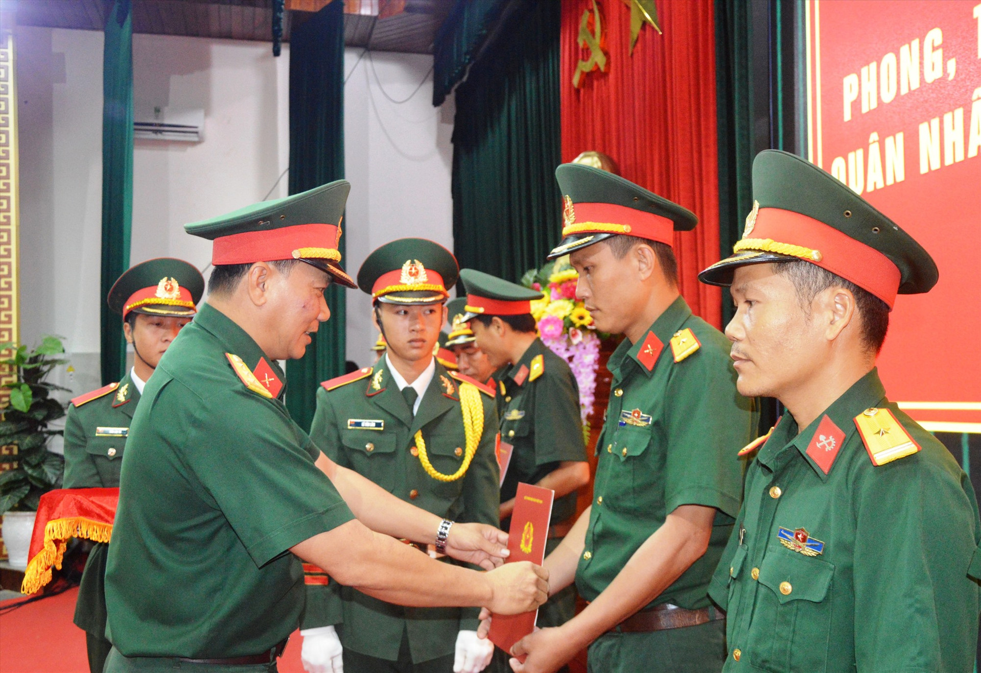 Chính ủy Bộ CHQS tỉnh trao quyết định cho cán bộ sĩ quan cấp thiếu tá.