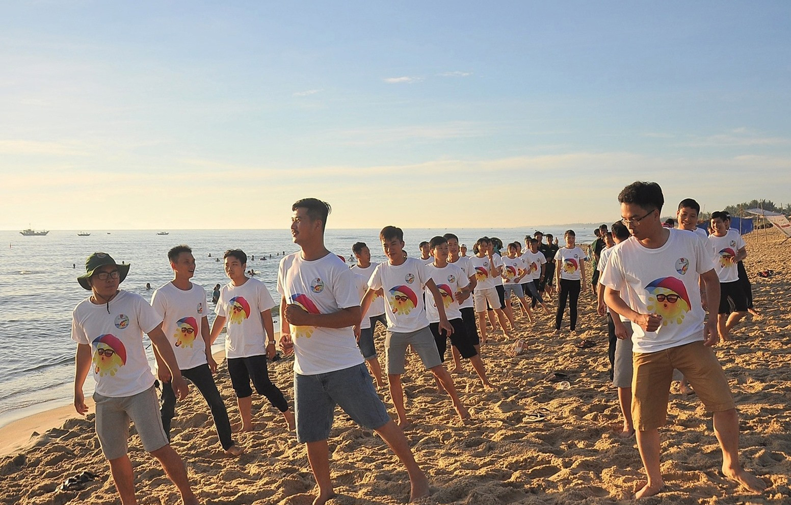 Cán bộ đoàn hào hứng với các bài thể dục khởi động ngày mới tại bãi biển từ rạng sáng. Ảnh: VINH ANH