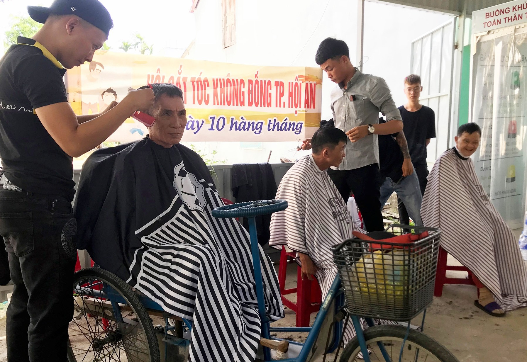 Nhóm thợ Tuấn Liên cắt tóc miễn phí cho người đến nhận gạo