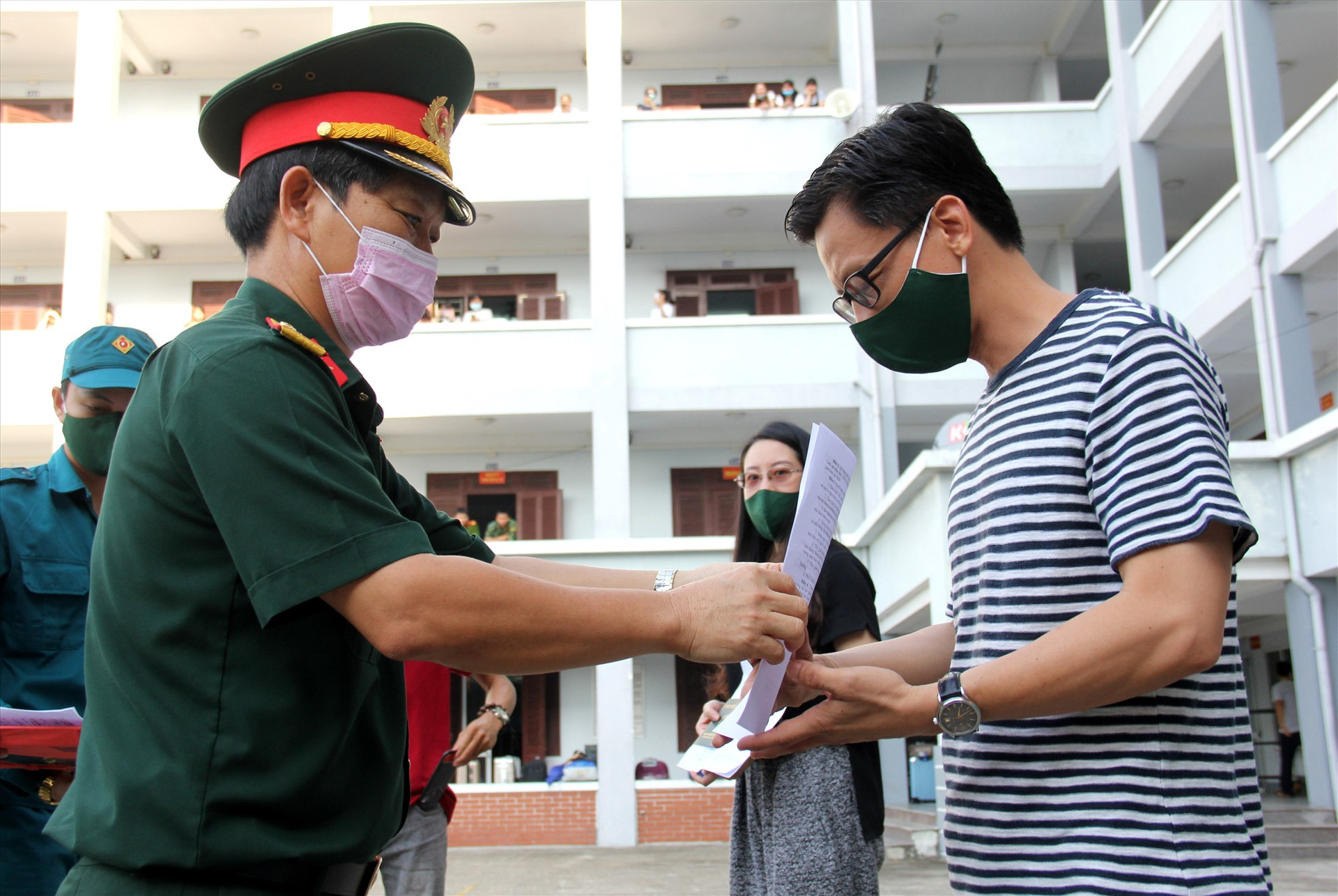 Đại tá Nguyễn Hữu Nghĩa - Phó Chỉ huy trưởng Bộ Chỉ huy Quân sự tỉnh trao chứng nhận hoàn thành cách ly cho các công dân. Ảnh: A.N