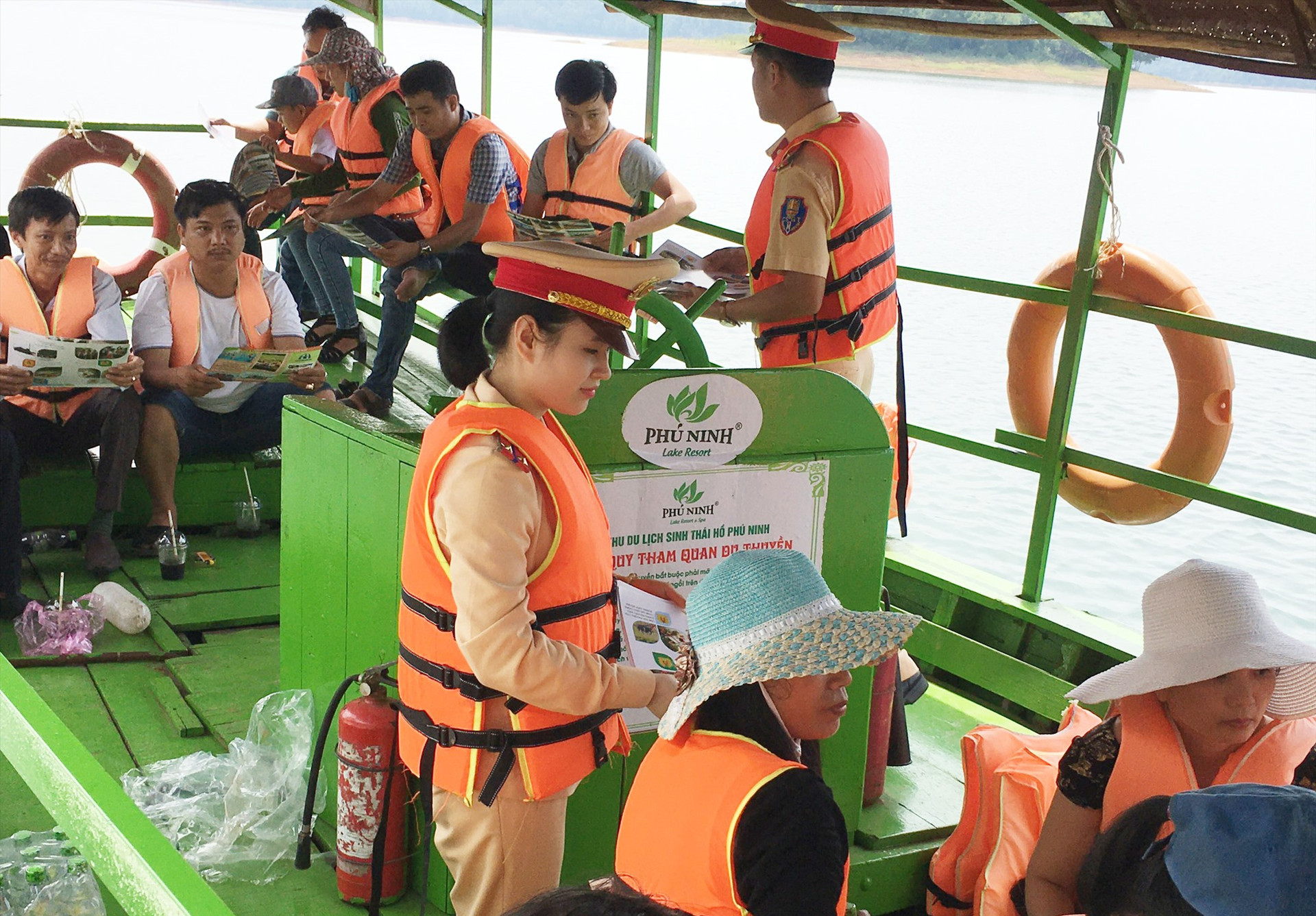 Cảnh sát đường thủy tuyên truyền, phát tờ rơi cho du khách ở hồ Phú Ninh. Ảnh: T.C