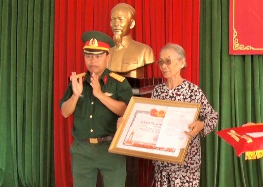 Thân nhân liệt sĩ Lê Khóa nhận bằng Tổ quốc ghi công. Ảnh: HẢI CHÂU