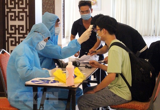 Kiểm tra sức khỏe của người cách ly. (Ảnh: TTXVN/Vietnam+)