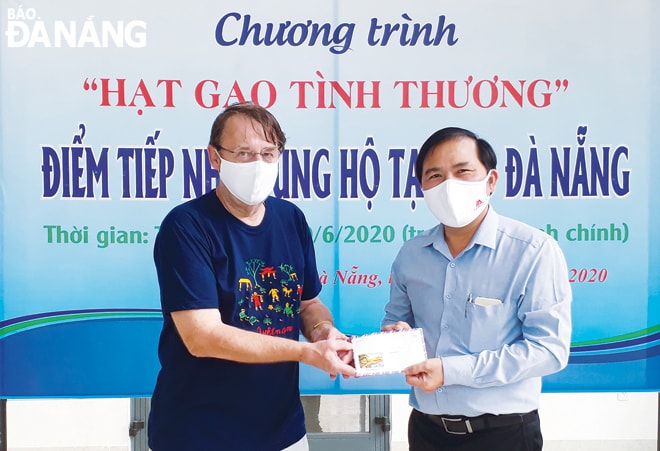 Ông Demaseure Thierry (trái) ủng hộ 5 triệu đồng cho chương trình “Hạt gạo tình thương” tại Báo Đà Nẵng. Ảnh: TÚ PHƯƠNG