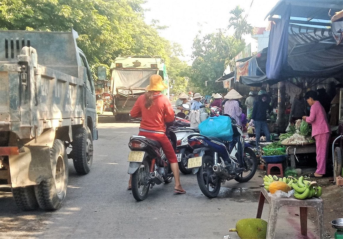 Ảnh 3: Chợ tự phát trên đoạn đường qua thôn Khương Mỹ (xã Tam Xuân 1, Núi Thành) rất nguy hiểm cho tính mạng người mua, kẻ bán. Ảnh: HOÀI AN