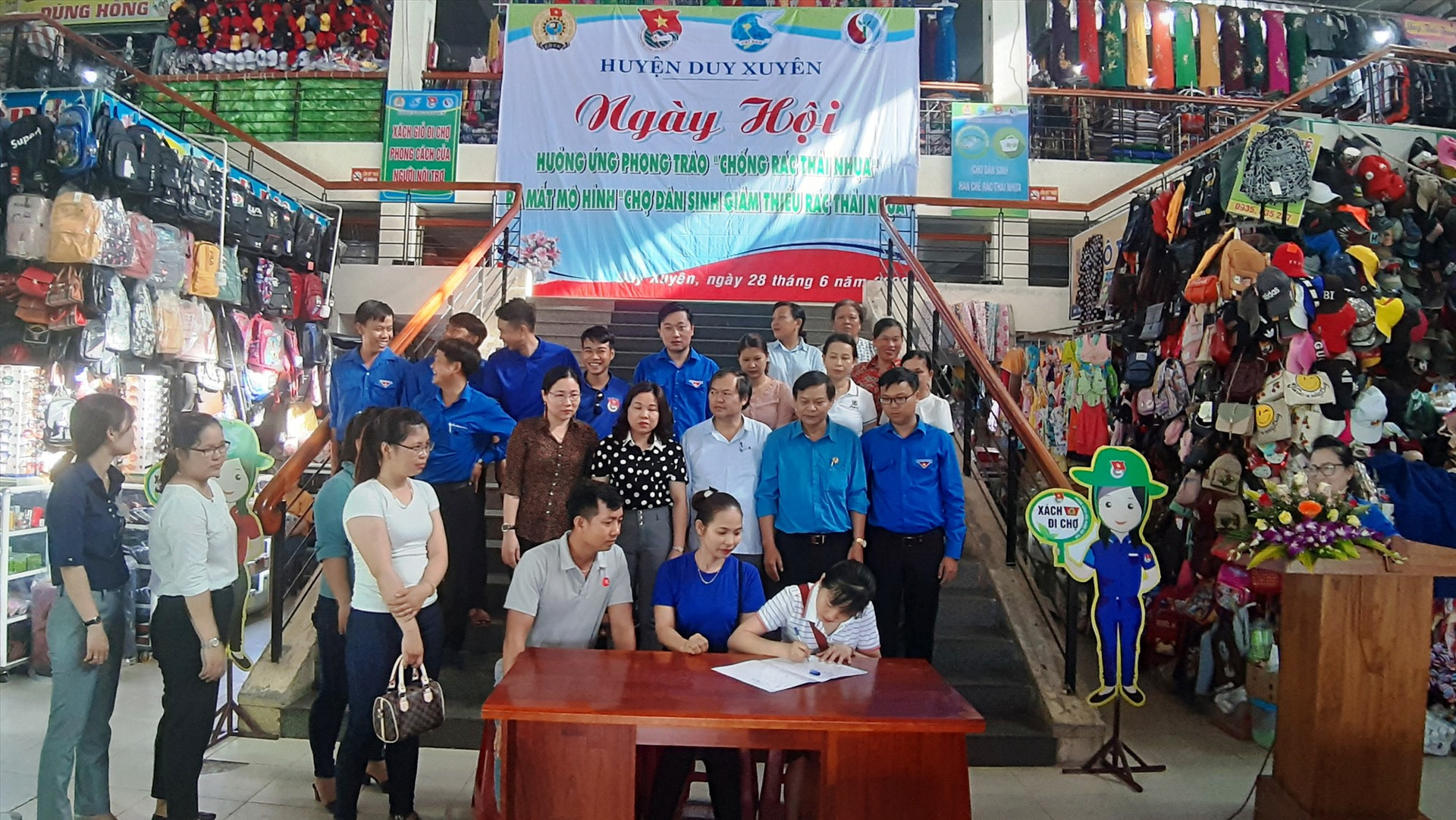 Các ban ngành, đoàn thể ở huyện Duy Xuyên và các xã, thị trấn cùng tiểu thương chợ Nam Phước ký cam kết chống rác thải nhựa. Ảnh: H.N