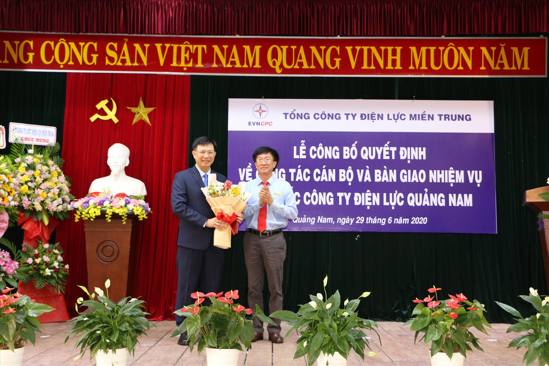 Bí thư Đảng ủy, Chủ tịch HĐTV EVNCPC Trương Thiết Hùng (phải) trao quyết định và tặng hoa cho tân Giám đốc PC Quảng Nam Nguyễn Hữu Khánh.