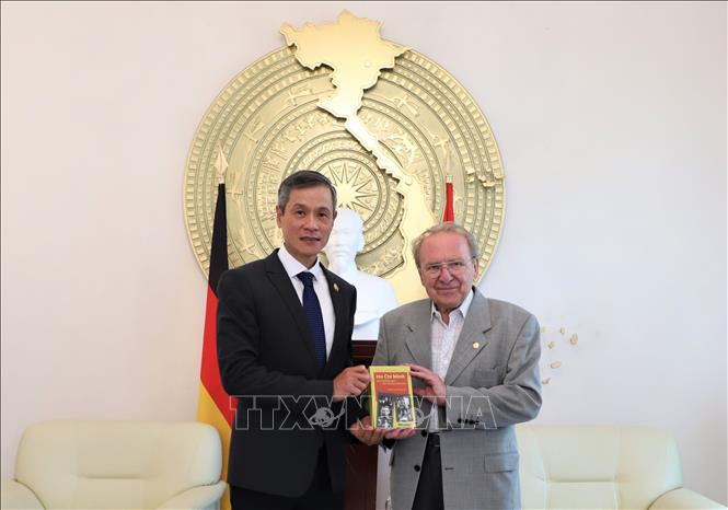 Nhà báo Hellmut Kapfenberger trao tặng Đại sứ Nguyễn Minh Vũ cuốn sách “Tiểu sử chính trị Hồ Chí Minh”. Ảnh: Thanh Bình-PV TTXVN tại Đức