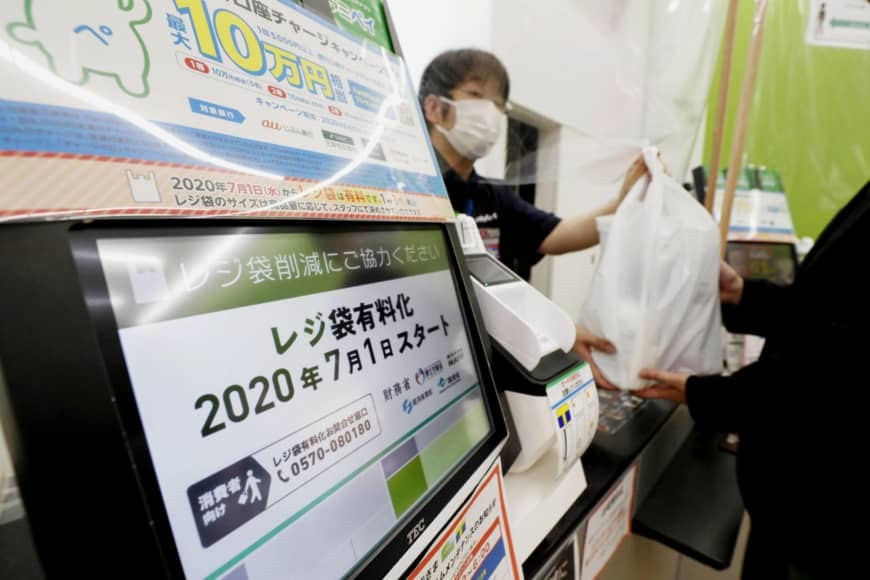 Cửa hàng tiện lợi FamilyMart tại Nhật dán thông báo về việc thu phí túi ni lông. Ảnh: KYODO