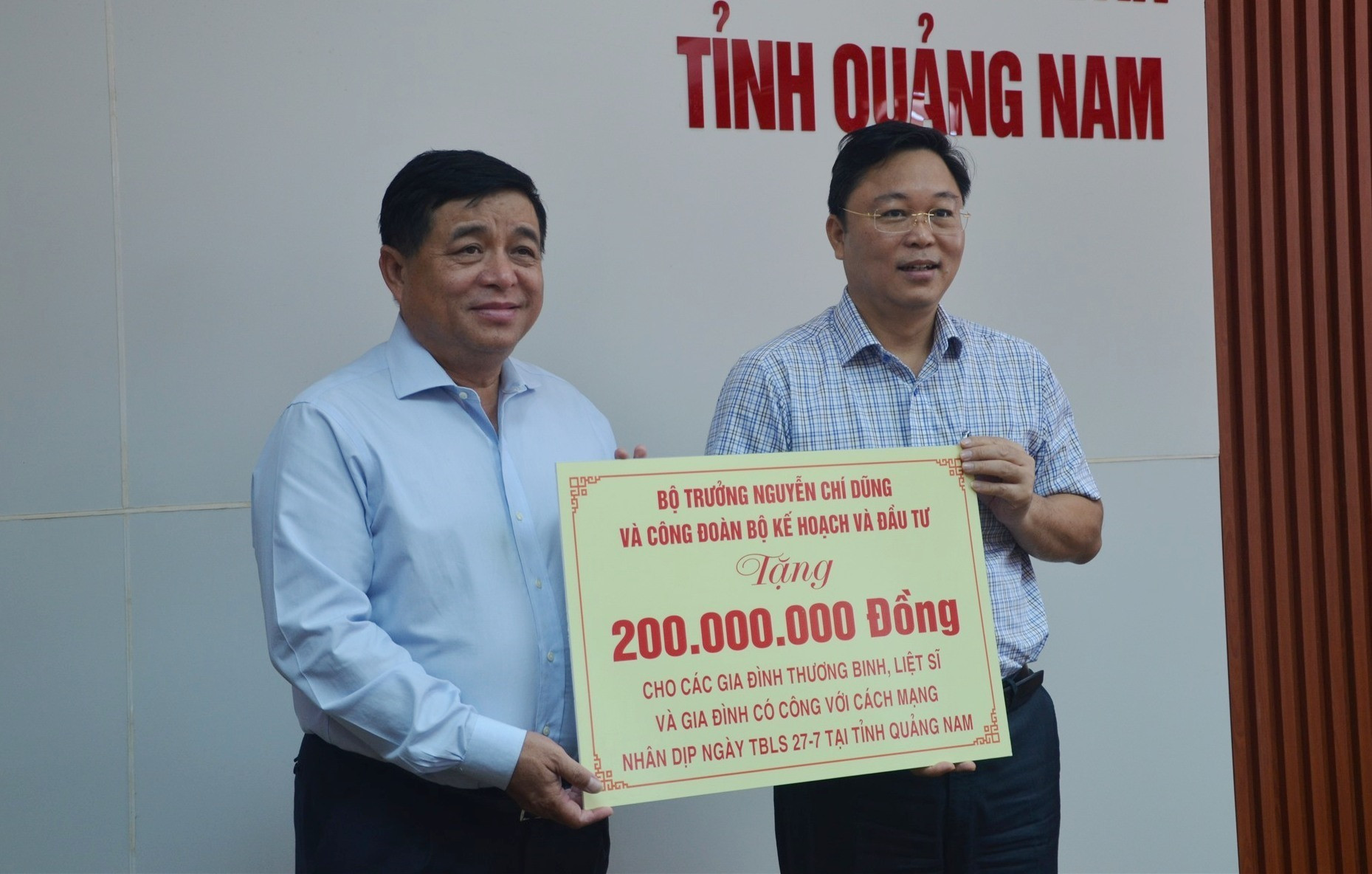 Bộ trưởng Nguyễn Chí Dũng trao 200 triệu đồng hỗ trợ các gia đình chính sách trên địa bàn Quảng Nam. Ảnh: P.V