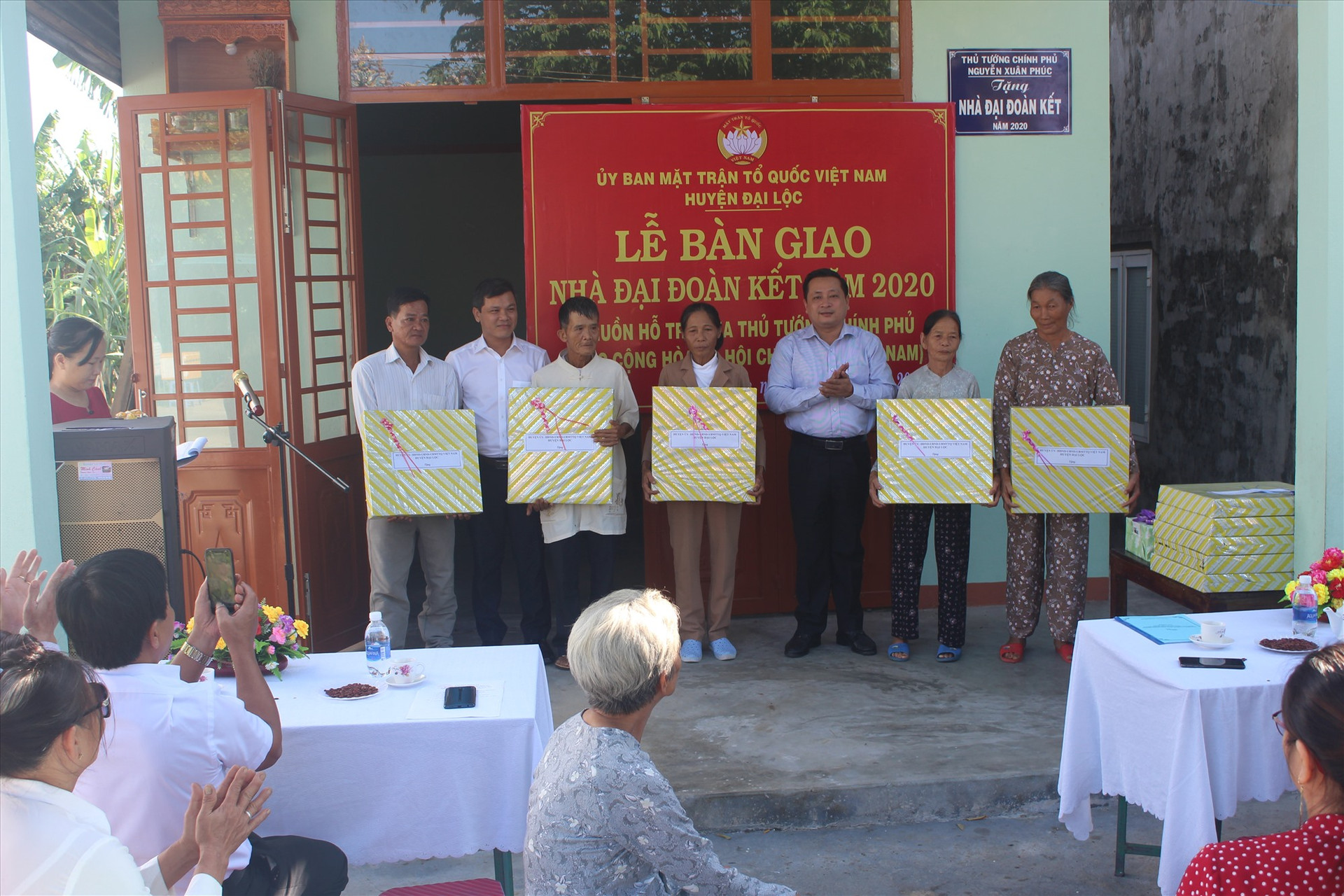 Lãnh đạo huyện Đại Lộc tặng quà chúc mừng các gia đình được nhận bàn giao nhà. Ảnh: XT