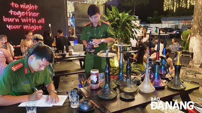 Lực lượng Công an quận Hải Châu lập biên bản xử lý một cơ sở kinh doanh vi phạm. Ảnh: PHƯƠNG CHI