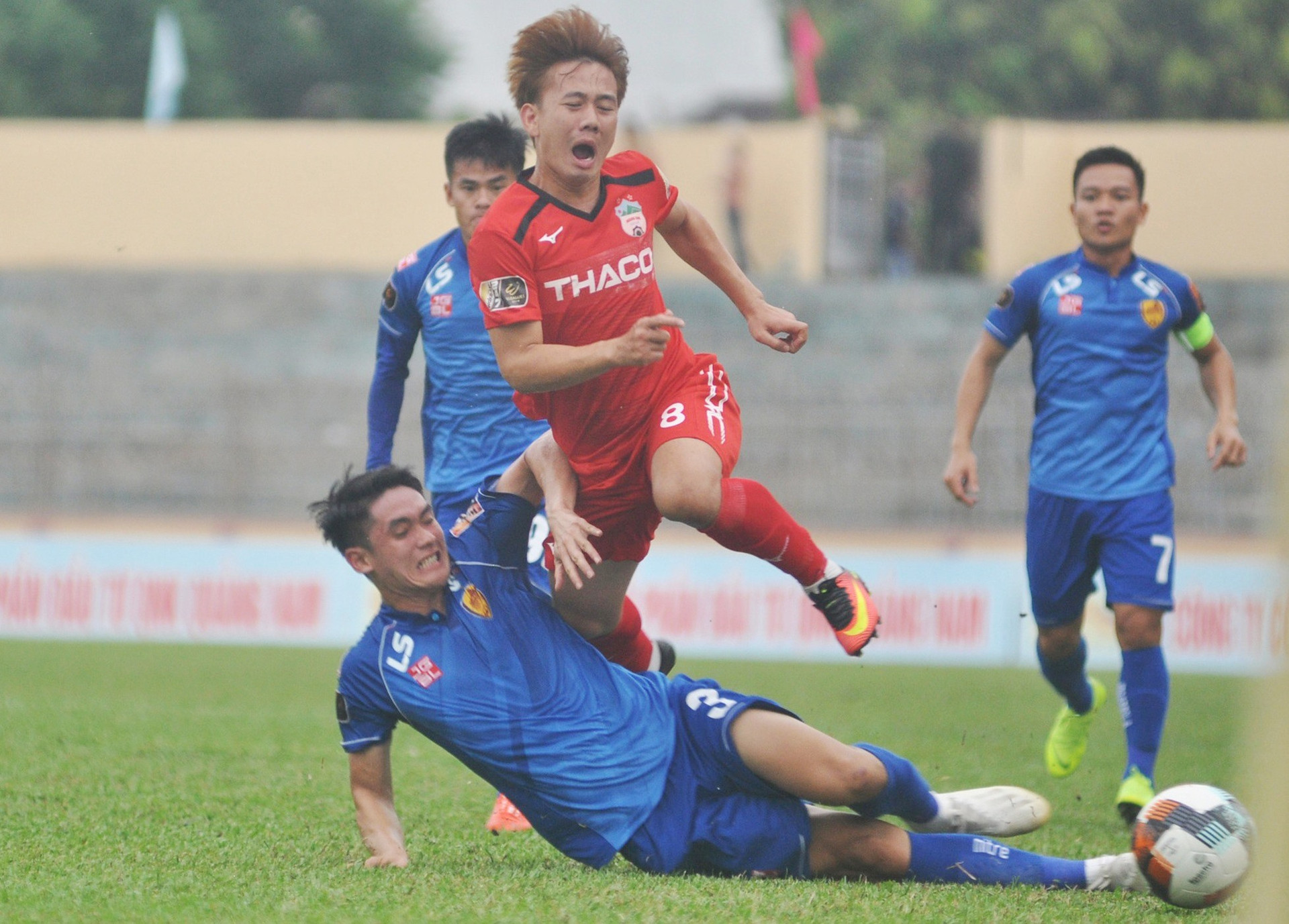 Trung vệ Tấn Sinh (áo xanh) tranh chấp quyết liệt với Minh Vương của Hoàng Anh Gia Lai ở V-League 2019. Ảnh: A.S