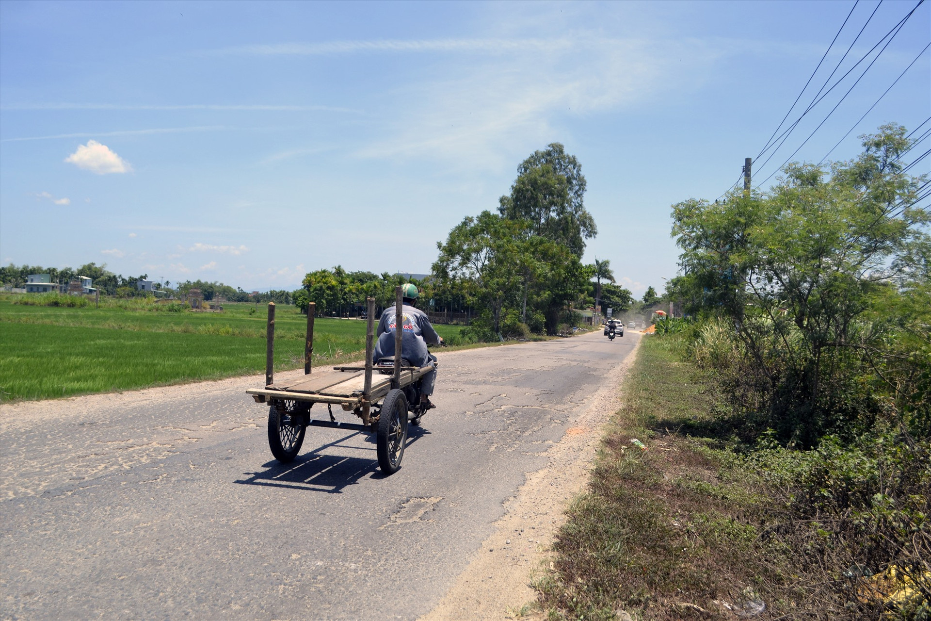 Xe máy kéo xe bò trên tuyến ĐT608 qua thị xã Điện Bàn. Ảnh: KHẢI KHIÊM