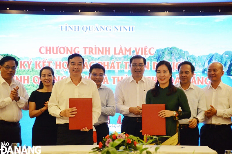 Đại diện lãnh đạo hai địa phương ký kết biên bản hợp tác phát triển du lịch. Ảnh: THU HÀ