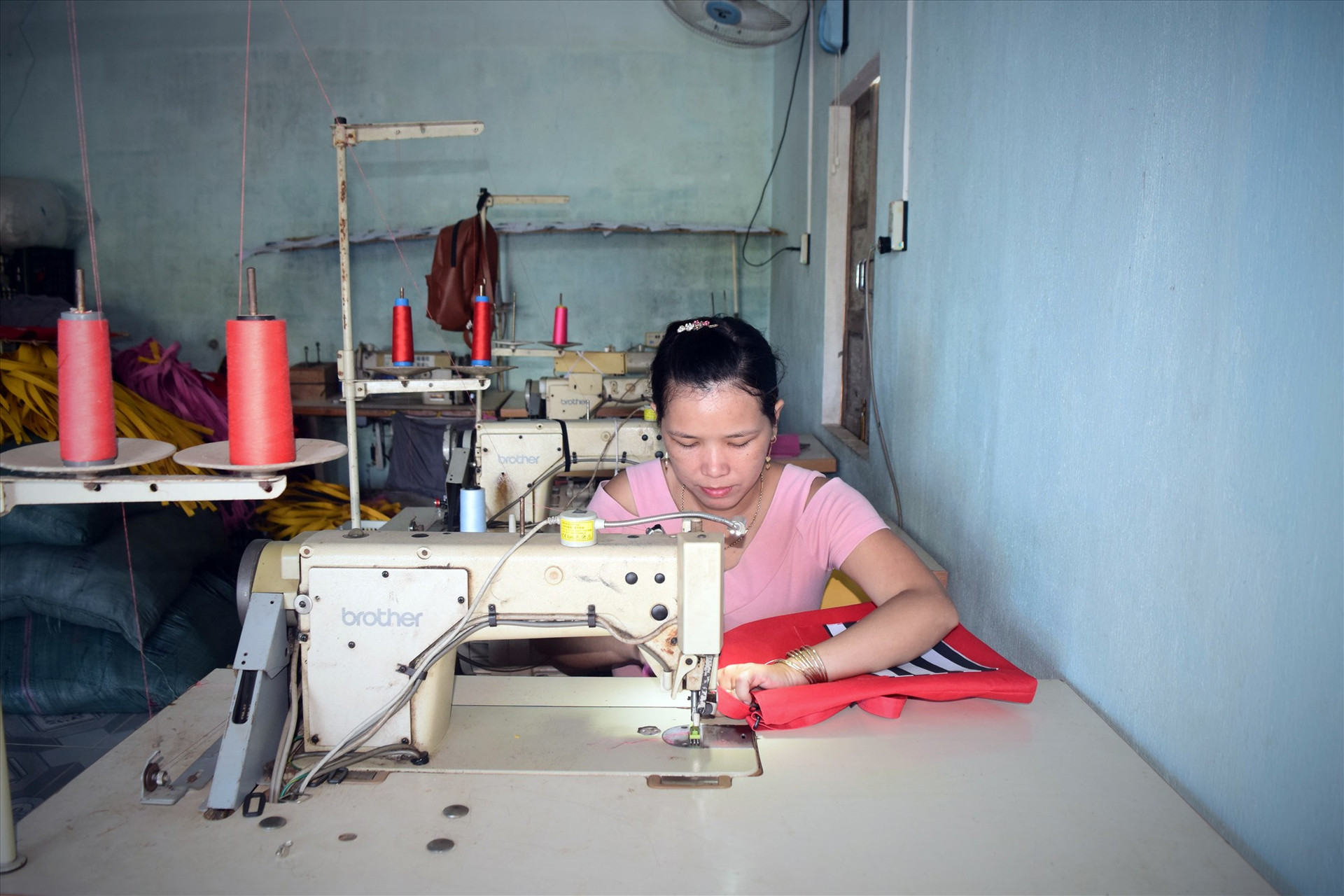 Chị Nguyễn Thị Tâm may các sản phẩm túi xách tại xưởng của mình. Ảnh: L.C