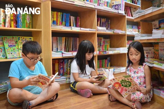 Các đơn vị xuất bản ngày càng chú trọng đầu tư về  nội dung và hình thức cho sách. TRONG ẢNH: Các em nhỏ say sưa đọc sách tại Nhà sách Fahasa Đà Nẵng. Ảnh: QUỲNH TRANG  