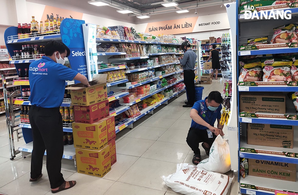 Nhân viên Siêu thị Co.opmart Sơn Trà đang xếp hàng bổ sung lên kệ. (Ảnh chụp chiều 30-7). Ảnh: VĂN HOÀNG