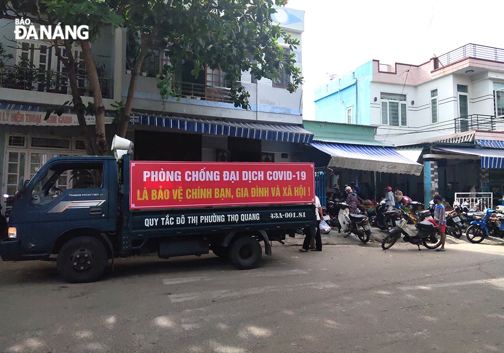 Lực lượng chức năng tại các địa phương tăng cường công tác tuyên truyền người dân phòng, chống dịch bệnh; không mua tích trữ hàng hóa, bảo đảm an ninh trật tự tại chợ. (Ảnh chụp tại chợ Chiều lúc 14 giờ 40 ngày 30-7). Ảnh: VĂN HOÀNG