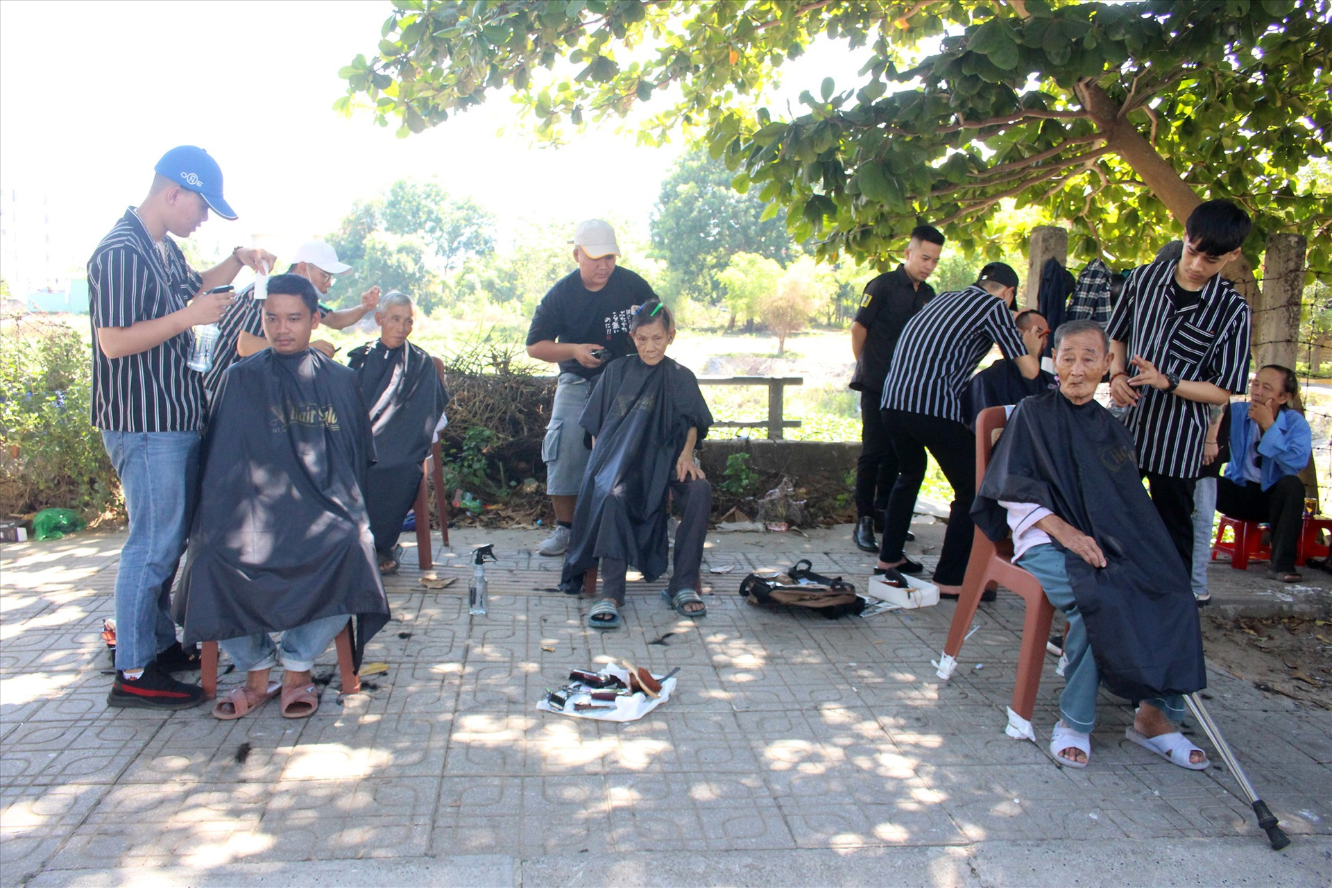 Các bạn trẻ cắt tóc từ thiện trên vỉa hè vào tháng 6 vừa qua. Ảnh: LY HUYỀN