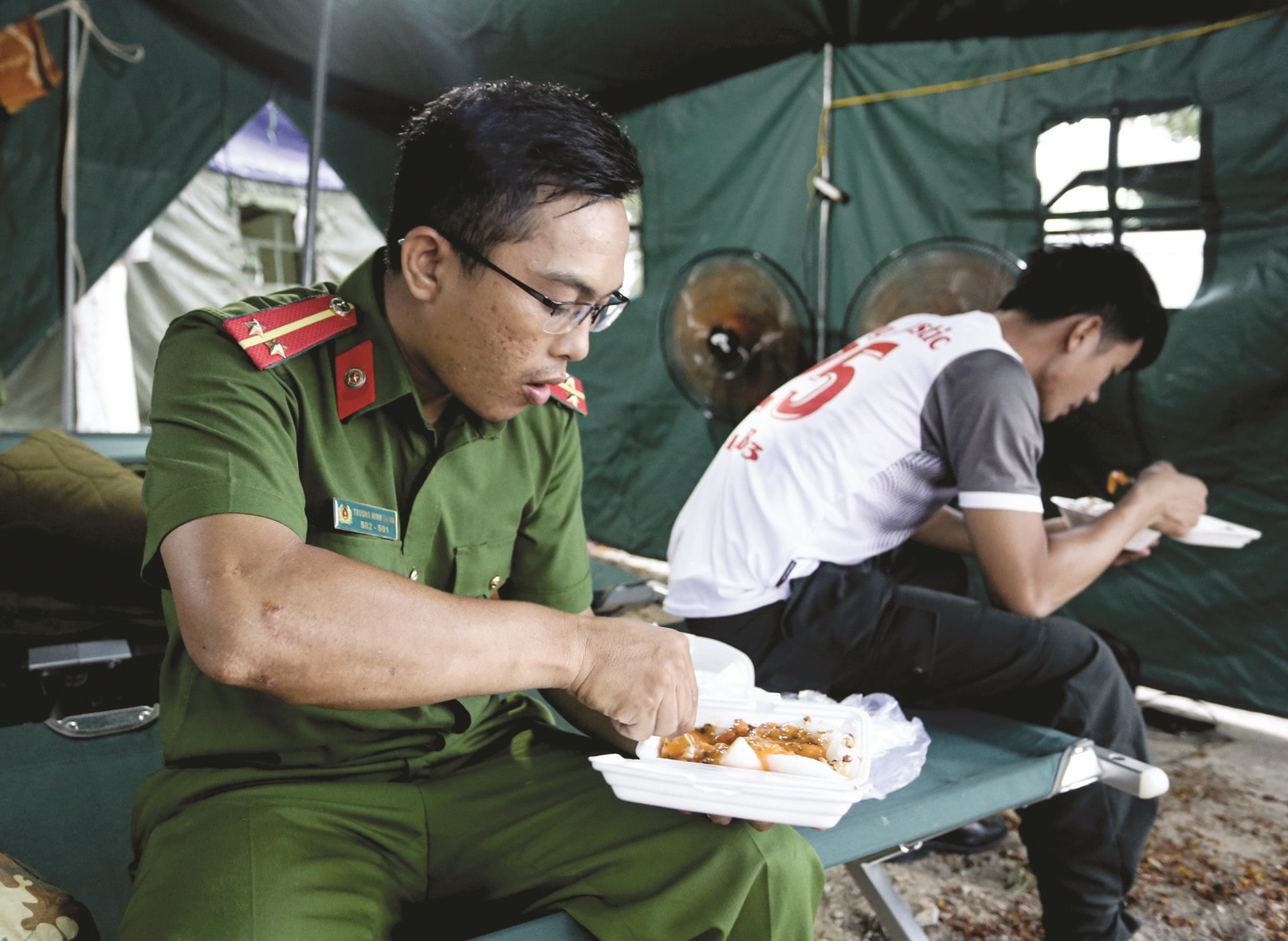 Bữa ăn vội vã trong lán trại của các chiến sĩ Cảnh sát cơ động (Công an tỉnh).Ảnh: SƠN THỦY