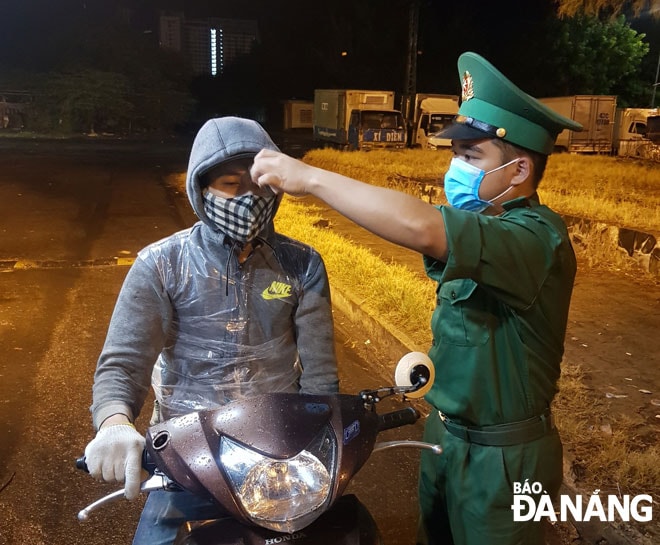 Lực lượng biên phòng quận Sơn Trà cũng được bố trí để đo thân nhiệt đối với người ra vào cảng cá Thọ Quang. Ảnh: LÂM MAI