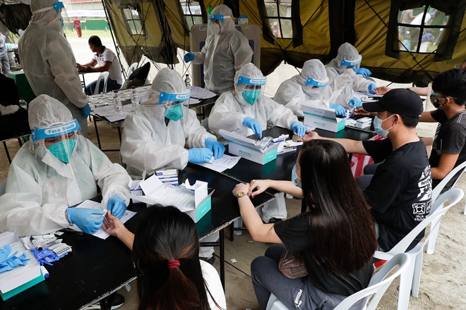Các nhân viên y tế lấy mẫu xét nghiệm SARS-CoV-2 ở thủ đô Manila của Philippines. Ngày 1-8, Philippines ghi nhận gần 5.000 ca nhiễm mới. Ảnh: AP