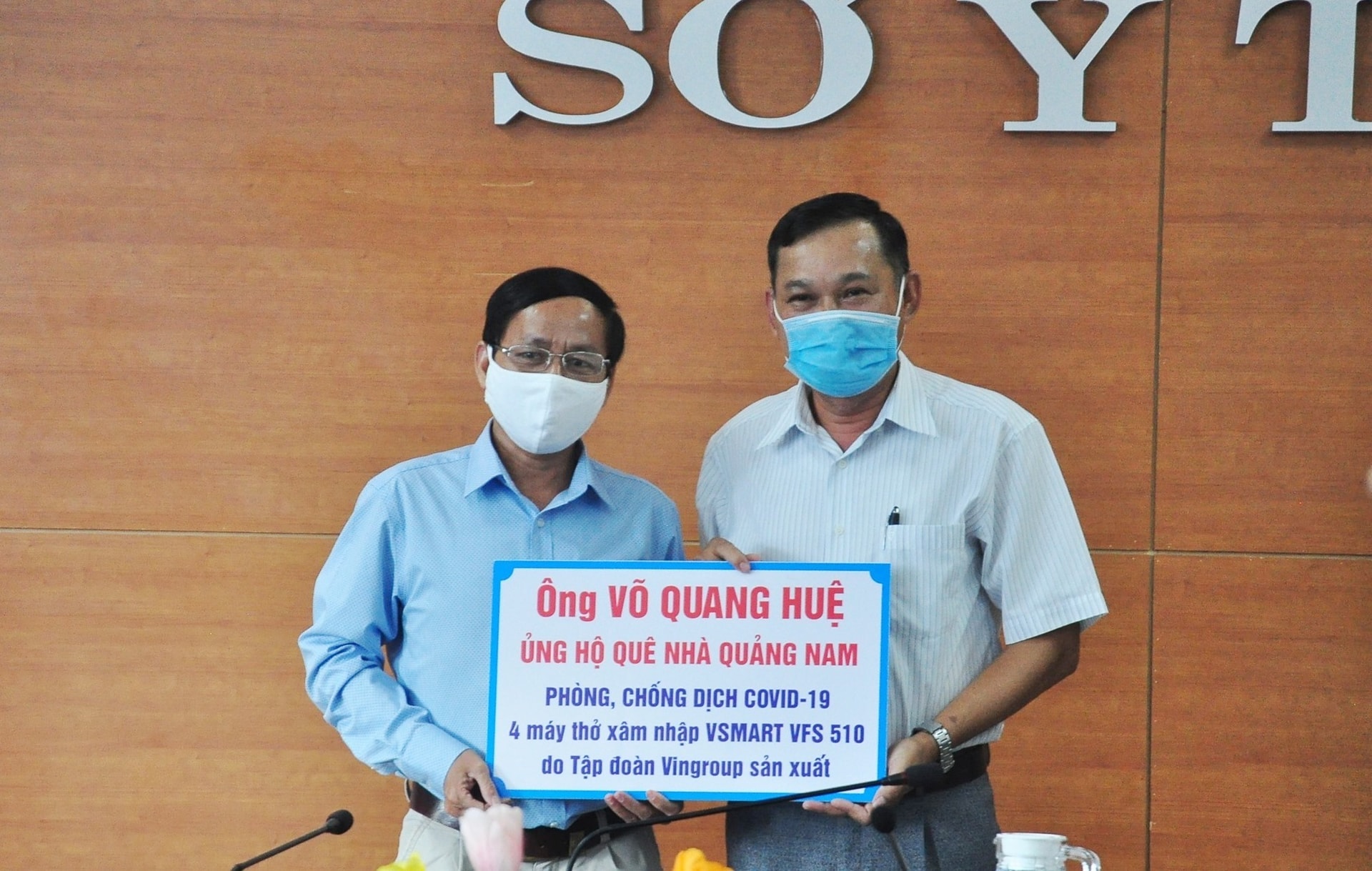 A representative of Mr. Hue's family (R) gives the symbol of 4 ventilators worth VND740 million to the Quang Nam provincial Department of Health.