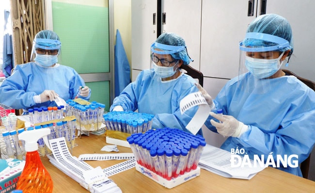 Ban Chỉ đạo phòng, chống Covid-19 yêu cầu ngành y tế đẩy nhanh tốc độ xét nghiệm SARS-CoV-2. Trong ảnh: Nhân viên CDC Đà Nẵng tiếp nhận, mã hóa các mẫu bệnh phẩm trước khi đưa đi xét nghiệm. Ảnh: PHAN CHUNG