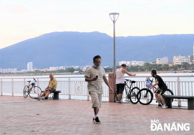 Người dân vô tư tập thể dục, hóng gió, không đeo khẩu trang dọc vỉa hè đường Bạch Đằng. Ảnh chụp chiều 10-8. Ảnh: H.H