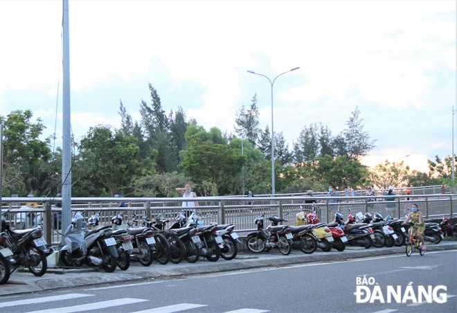 Người dân dựng xe tại đầu cầu Thuận Phước (phía đường Nguyễn Tất Thành) để đi bộ lên cầu tập thể dục, hóng gió bất chấp quy định giãn cách. Ảnh chụp chiều 10-8. Ảnh: H.H